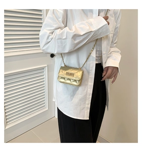 Detailansicht der gold-metallischen Mini-Stepptasche mit Drehverschluss und Kette