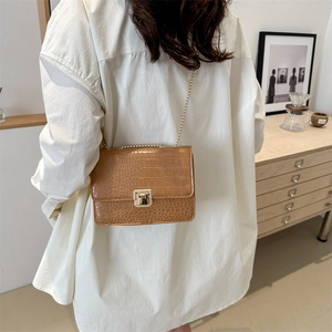 Petit sac carré marron motif crocodile avec bandoulière chaîne dorée porté par mannequin