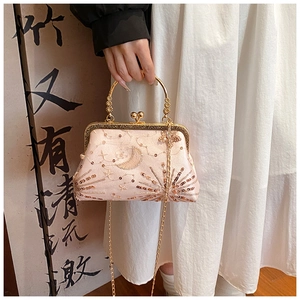 Dettaglio pochette vintage rosa con paillettes dorate luna stelle e manico in metallo