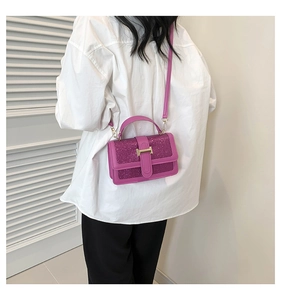 Rear view of a model wearing a purple sequin crossbody bag with golden H clasp detail