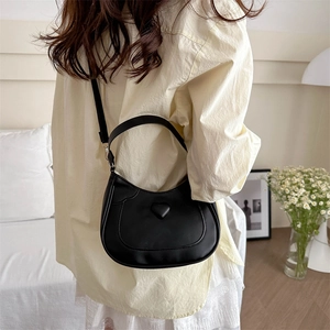 Chic black half-moon crossbody bag with heart detail and adjustable shoulder strap