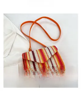 Detailed macro view of ethnic woven crossbody bag with colorful wave patterns on white fabric