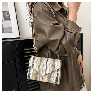 Detail of colorful woven wave pattern and envelope flap on a chic crossbody bag