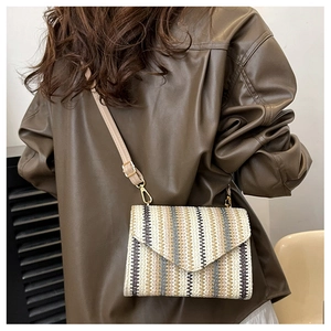 Detail of woven striped crossbody bag with envelope flap and adjustable leather strap