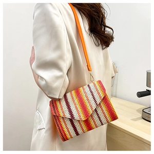 Detail of multi-color woven crossbody bag featuring textured stripes and orange strap