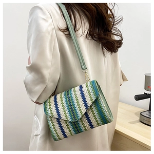 Detail of multi-color woven cross-body bag with light green leather strap and gold buckle