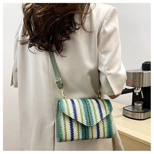 Detail of woven crossbody bag with blue and green stripes and adjustable leather strap