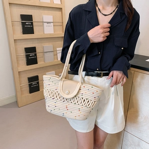 Woven straw beach tote bag with colorful specks and a decorative pearl closure
