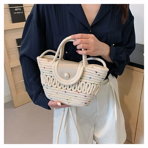 Détail d'un sac à main en paille tressée avec fermoir perle et coutures colorées