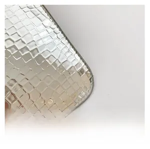 Close-up of silver faux crocodile leather texture with metallic glossy finish