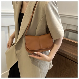 Borsa baguette vintage marrone indossata da modella in stile minimalista tinta unita
