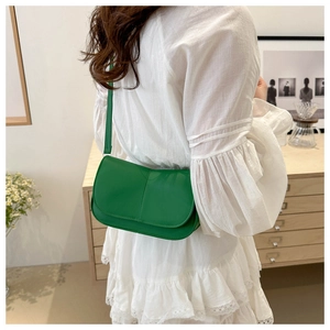 Dettaglio della borsa a tracolla verde smeraldo minimalista in ecopelle lucida di qualità