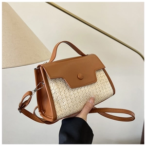 Détail du sac bandoulière tissé avec tissu crème et finitions en cuir marron