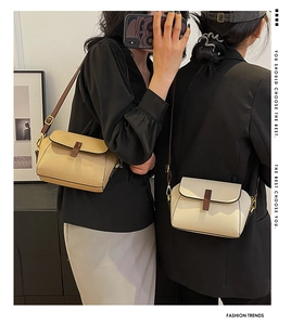 Close-up of khaki and cream crossbody shell bags showing lychee texture and gold hardware
