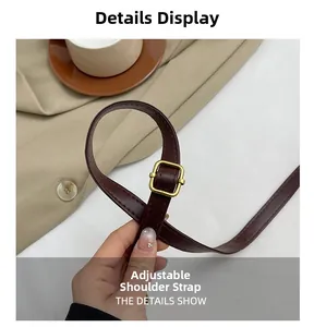 Detail view of adjustable dark brown faux leather shoulder strap with gold metal buckle