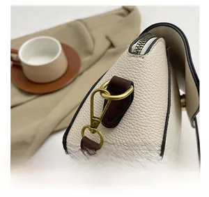 Detailed macro view of retro gold hardware and premium pebble grain leather on a crossbody bag