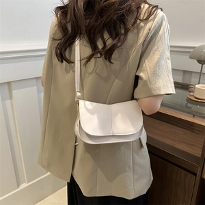 Borsa a sella chic in pelle crema con cuciture verticali e fibbie in metallo dorato