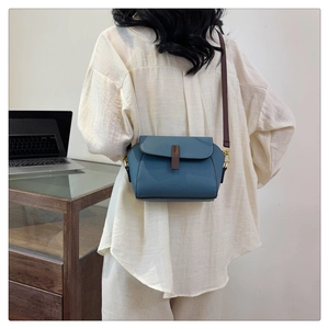 Detailed back view of a blue lychee pattern leather crossbody bag worn by a model