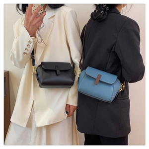 Detail of minimalist leather crossbody bags in black and blue with gold hardware details