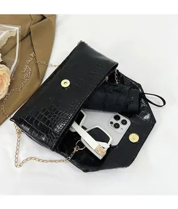 Top view of black croc-embossed bag interior showing space for phone, umbrella, and sunglasses