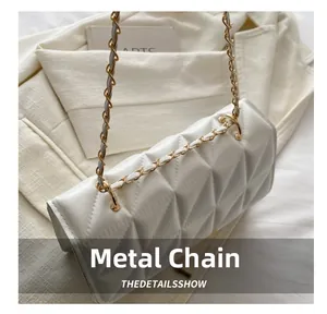 Détail du sac bandoulière blanc cassé matelassé avec chaîne métallique et lanière