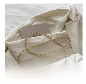 Détail du sac matelassé blanc avec chaîne élégante en métal doré et cuir entrelacé