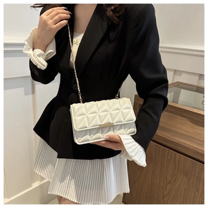Gros plan sur un sac bandoulière blanc matelassé avec chaîne dorée et boucle métallique