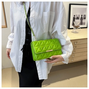 Détail du sac bandoulière matelassé vert vif avec fermoir doré et bandoulière chaîne