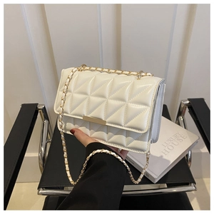 Gros plan d'un sac bandoulière blanc matelassé avec chaîne et fermoir dorés