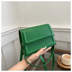 Detail der grünen Ledertasche mit rechteckigem Rahmendesign auf der Klappe für Damen