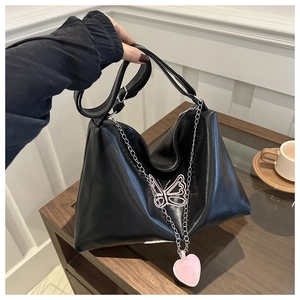 Détail du sac en cuir PU noir brillant avec papillon rose et chaîne en métal argenté