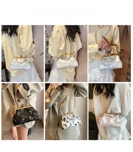 Detail of vintage crossbody bag with butterfly embroidery and metal clasp closure