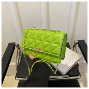 Détail du sac bandoulière matelassé vert fluo avec chaîne dorée et fermoir métal