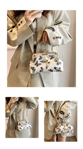Detailed embroidery of black and gold butterflies on a white satin vintage clip bag