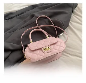 Close-up of pink quilted embroidery texture with gold twist lock on the baguette bag