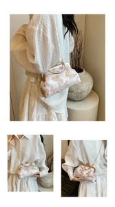 Detail of silk vintage bag featuring pink butterfly embroidery and metal ring handle