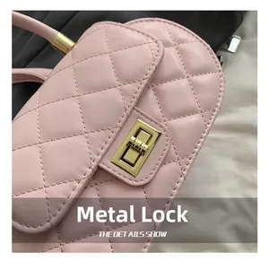Detailed macro view of the pink quilted faux leather bag featuring a gold hardware lock