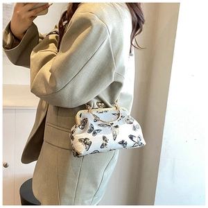 Detail of vintage frame bag with black butterfly embroidery on beige silk fabric