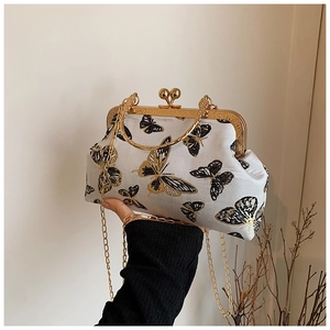 Detail of vintage hand-held bag with exquisite butterfly embroidery and gold metal clasp