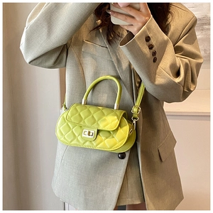 Close-up of vibrant lime green quilted bag with golden twist lock on khaki blazer