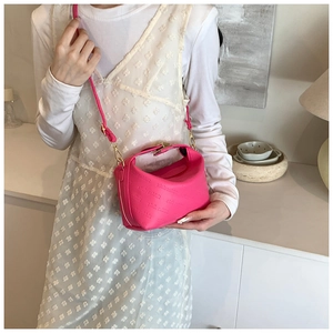 Close-up of pink leather pillow bag with rich rabbit embossed text and gold buckle detail