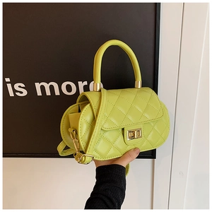 Detail of lime green quilted baguette bag with gold twist lock and rounded silhouette