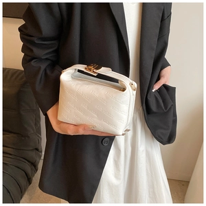 Detail of white leather handbag featuring rich rabbit embossed patterns and gold clasp