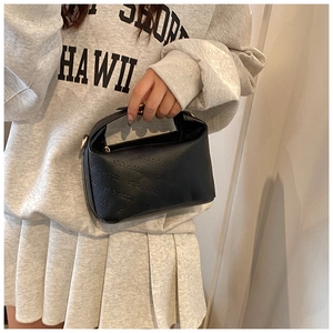 Detail of black leather handbag featuring embossed rich rabbit texture and metal hardware