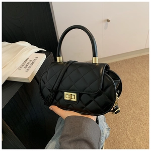Macro view of black quilted faux leather handbag with premium golden twist lock detail
