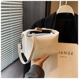 Detail of white leather shoulder bag featuring rich rabbit embossed logo and gold hardware