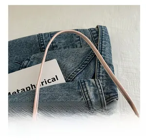 Detail view of the smooth pink leather handle on a minimalist bowknot tote bag