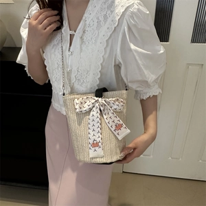 Chic beige woven tote bag with black leather handle and floral silk bow decoration