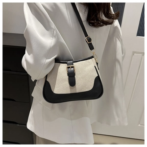 Detail of vintage canvas and black leather shoulder bag with adjustable strap and buckle