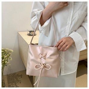 Detail of soft pink tote bag with chic silver eyelets and a long bow ribbon finish